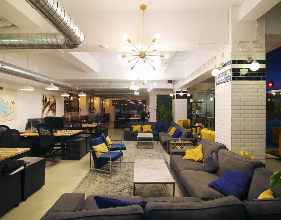 An amazing picture of Virtual Office's open space with big sofas, pillars, blue and yellow color