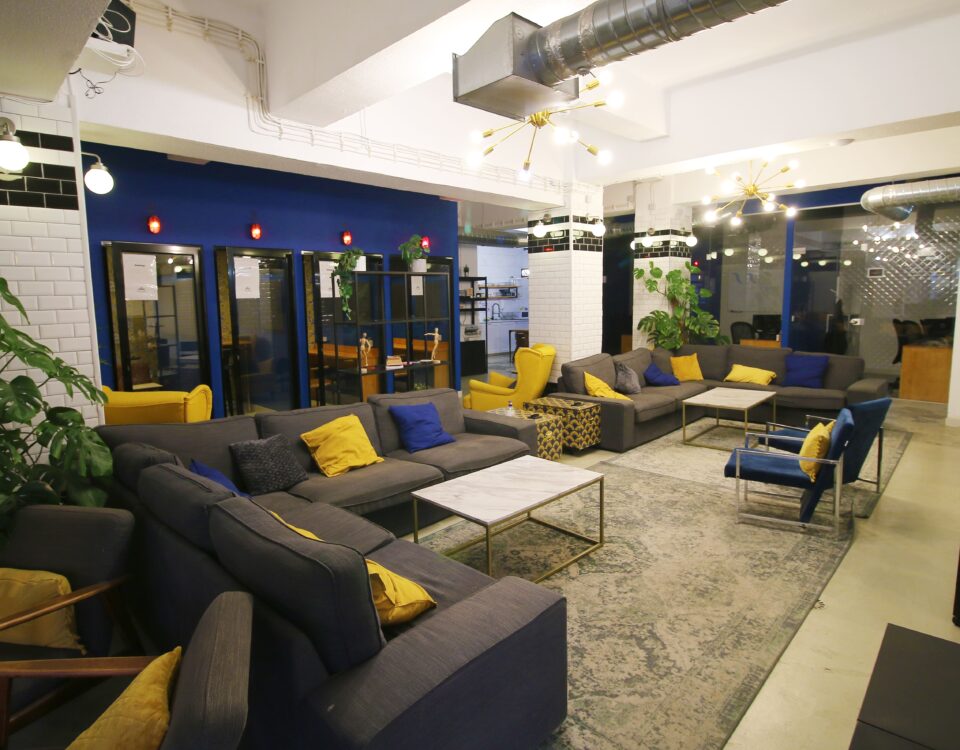 An amazing picture of Virtual Office's open space with big sofas, pillars, blue and yellow color