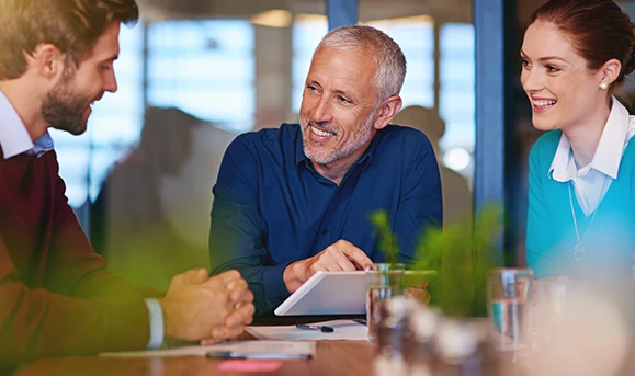 three European looking people talking in a office smiling to represent the public target of the Virtual Office Lisbon
